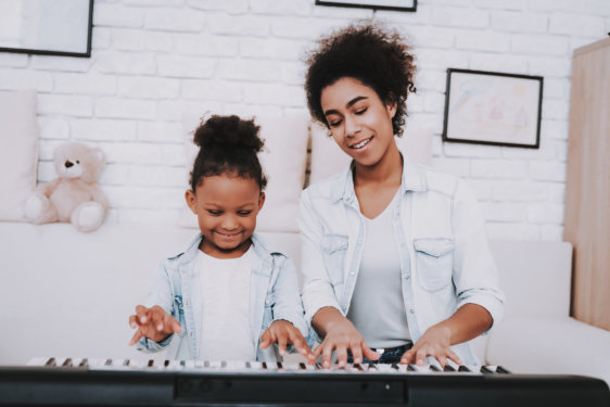 mother and daughter playing piano