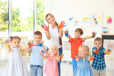 teacher and students waving their hands with paint on it